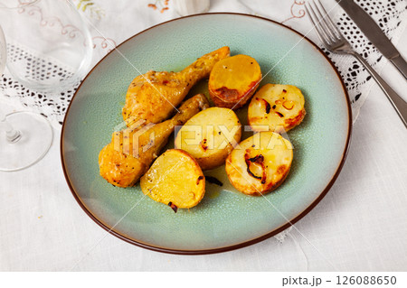 Barbecued chicken leg with boiled potatoes closeup on plate 126088650