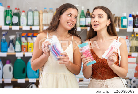 Two girls friends choose disposable razor in household shop Two girls friends choose disposable razor in household shop 126089068