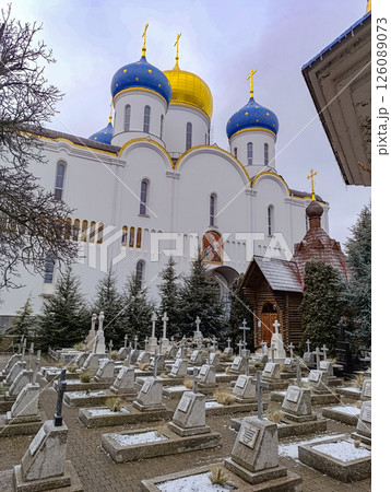 Church temple with blue and yellow domes.The graves of believers against the backdrop of a beautiful temple. 126089073
