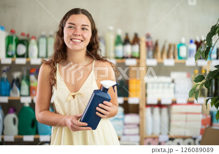 Young woman chooses cleaning spray in store 126089089