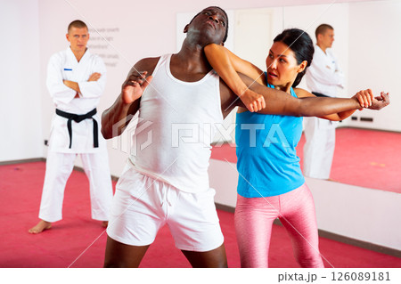 Men and woman training self-protection martial arts in gym Men and woman training self-protection martial arts in gym 126089181