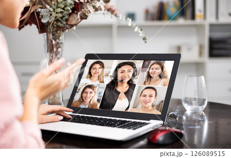 Woman talking with female co-workers via video call Woman talking with female co-workers via video call 126089515