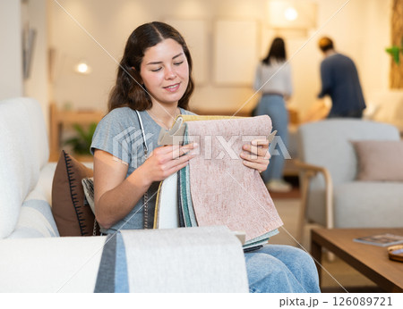 Young woman absorbing textile samples for furniture Young woman absorbing textile samples for furniture 126089721