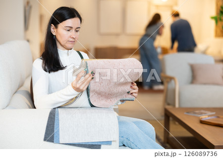 Woman deciding on material for couch in furniture shop 126089736