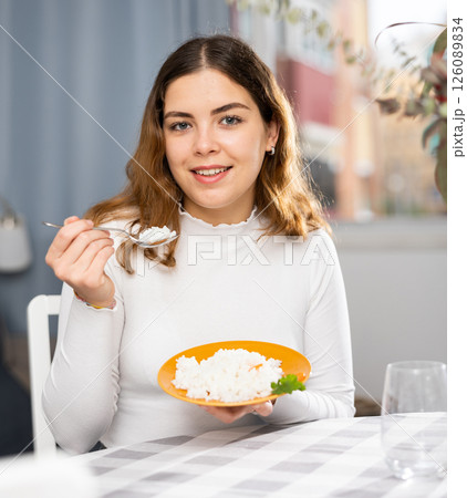 Emotional young woman eating rice at home 126089834