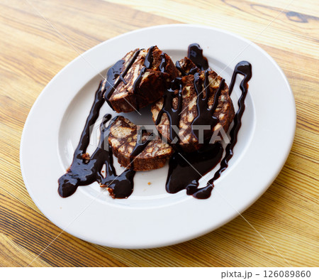 Served chocolate rolled cake with walnut on plate Served chocolate rolled cake with walnut on plate 126089860