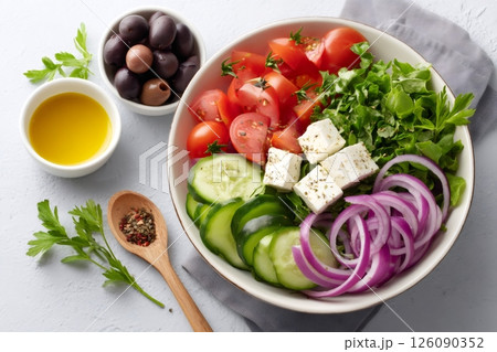 Greek salad with feta cheese, tomatoes, cucumbers, olives, red onion and lettuce seasoned with oregano and olive oil Greek salad with feta cheese, tomatoes, cucumbers, olives, red onion and lettuce seasoned with oregano and olive oil 126090352