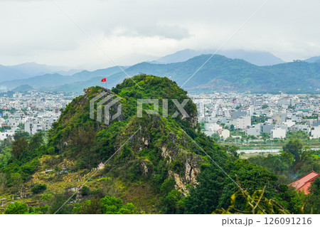 One of the Marble Mountains of Da Nang, the red flag of Vietnam on the top of the mountain 126091216