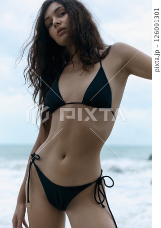 Beautiful young woman on beach. pretty girl in Bikini near sea. Beautiful young woman on beach. pretty girl in Bikini near sea. 126091301