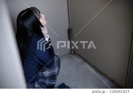 階段の一番上の屋上扉の前でしゃがみ込む女子高生 いじめ 不登校 不安 階段の一番上の屋上扉の前でしゃがみ込む女子高生 いじめ 不登校 不安 126091825