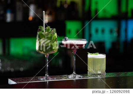 row of various colourfull alcoholic cocktails on a bar desk. Glasses of differen shapes. selective focus row of various colourfull alcoholic cocktails on a bar desk. Glasses of differen shapes. selective focus 126092098