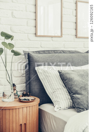 Stylish big comfortable grey bed with striped bed linen Stylish big comfortable grey bed with striped bed linen 126092165