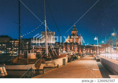 Helsinki, Finland. Pier With Boats, Pohjoisranta Street And View Of Uspenski Cathedral In Evening Night Illuminations. Night stars shining above street 126092507