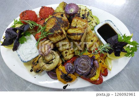 Baked sturgeon steaks with fresh salad greens 126092961