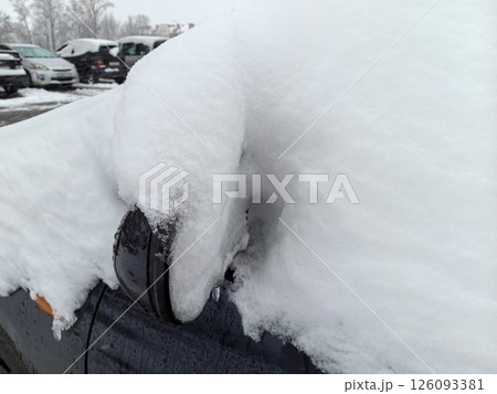 Spring snowfall covers parked vehicles, highlighting unusual weather patterns 126093381