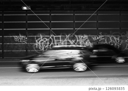 高架下に通るバイパスを疾走する車と何度も塗り重ねれられた汚い落書き 126093835