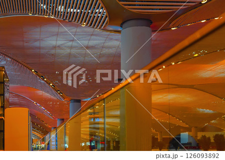 Architectural interior with illuminated curved ceiling panels, massive columns, glass reflections in warm toned lighting. Concept of innovation, futuristic design, modern space Architectural interior with illuminated curved ceiling panels, massive columns, glass reflections in warm toned lighting. Concept of innovation, futuristic design, modern space 126093892