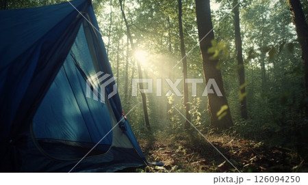 Blue Tent in a Sunlit Forest at Sunrise 126094250