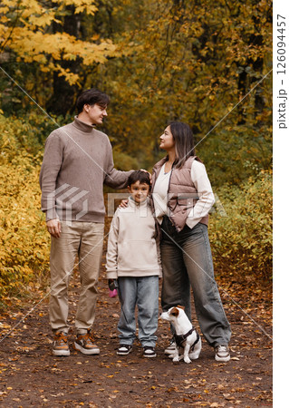 Happy family of three with dog in autumn park Happy family of three with dog in autumn park 126094457