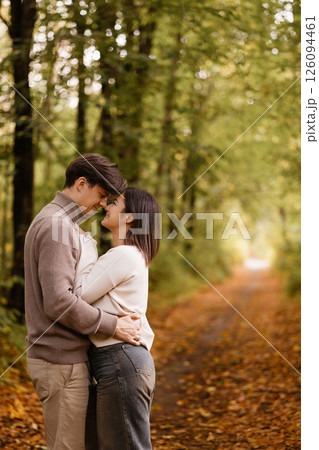 Happy couple embracing in autumn forest. Copy space. Happy couple embracing in autumn forest. Copy space. 126094461