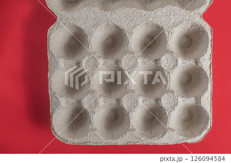 Reusable cardboard egg carton on a bright red background. Top view 126094584