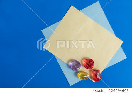 Colorful gemstones on vibrant paper with a blue background. Colorful gemstones on vibrant paper with a blue background. 126094608