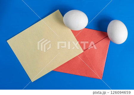 Colorful composition with white eggs, paper and envelope on a blue background. 126094659
