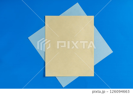Yellow and blue sheets arranged on a vibrant blue background surface. 126094663