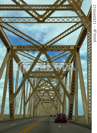 Driving Through Yellow Steel Truss Bridge Under Blue Sky 126095012