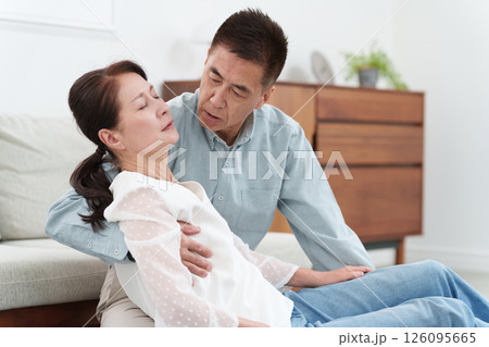 倒れるシニア女性を助けるシニア男性 126095665