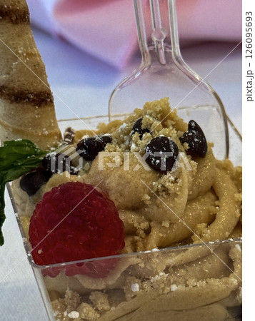 Gourmet Dessert in Clear Cup with Cookie Stick and Raspberry Garnish Gourmet Dessert in Clear Cup with Cookie Stick and Raspberry Garnish 126095693