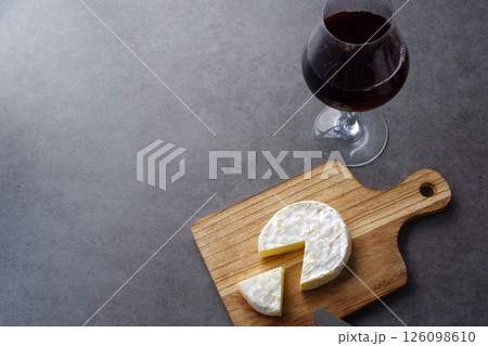 ワイングラスに注いだ赤ワインと、おつまみのカマンベールチーズで、リラックスのひととき ワイングラスに注いだ赤ワインと、おつまみのカマンベールチーズで、リラックスのひととき 126098610