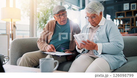 Senior couple, calculator and documents on sofa with finance, budget and review for bills in retirement. People, clipboard and partner with planning for wealth, saving or investment in living room 126098799