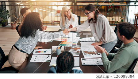 Business people, meeting and handshake for team with applause, praise or congratulations at creative agency. Market research, paperwork and female employees shaking hands for well done or success 126099394