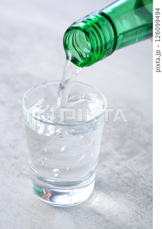 韓国の伝統的な蒸留酒、焼酎（ソジュ）をグラスに注ぐ 126099494