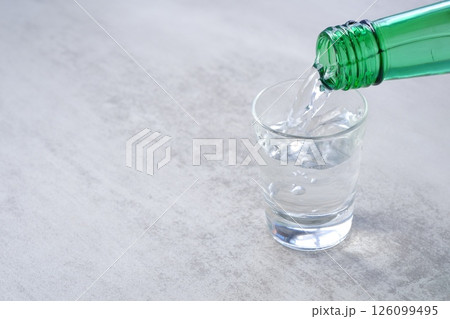 韓国の伝統的な蒸留酒、焼酎（ソジュ）をグラスに注ぐ 126099495