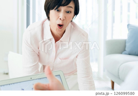 リビングでパソコンを見て喜ぶ中高年夫婦 リビングでパソコンを見て喜ぶ中高年夫婦 126099580