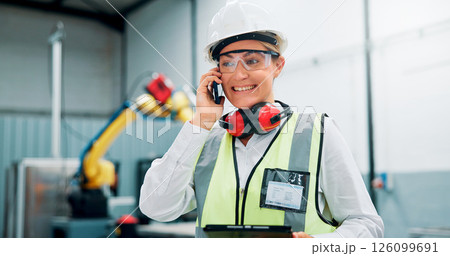 Phone call, engineer and woman with smile, talking and communication with contact for robotics in factory. Happy, employee and person with mobile for conversation, warehouse or plan for manufacturing 126099691