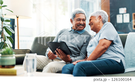 Mature couple, smile and happy with tablet, streaming and communication in living room. People, senior man and woman with funny meme, couch and house together in retirement with digital technology 126100164