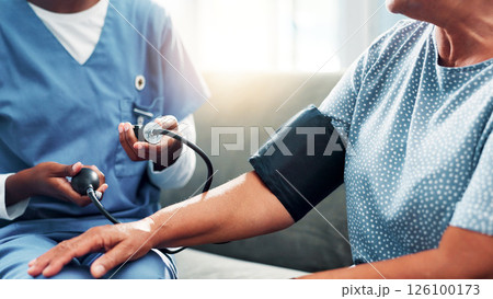 Mature woman, nurse and hands for blood pressure in nursing home, medical care or health exam on arm. Living room, diagnosis or conversation for healthcare, cardiovascular support or heart monitoring 126100173
