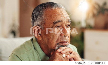 Sad, senior man or thinking in home with retirement loneliness, grief or remember memory with nostalgia. Face, mental health or elderly person with depression on sofa for loss, reflection or dementia 126100514