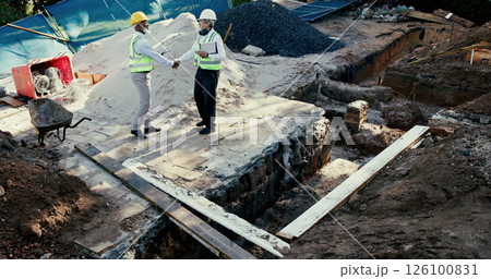 Construction site, handshake and engineer people in partnership outdoor to start foundation. Mature men, foreman or employees from above for excavation, agreement or collaboration and shaking hands Construction site, handshake and engineer people in partnership outdoor to start foundation. Mature men, foreman or employees from above for excavation, agreement or collaboration and shaking hands 126100831