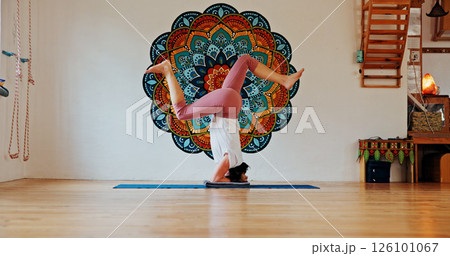 Balance, upside down or yoga and woman in class with wall art for fitness or wellness routine. Exercise, headstand or pilates and yogi person in studio with mandala symbol for holistic health Balance, upside down or yoga and woman in class with wall art for fitness or wellness routine. Exercise, headstand or pilates and yogi person in studio with mandala symbol for holistic health 126101067