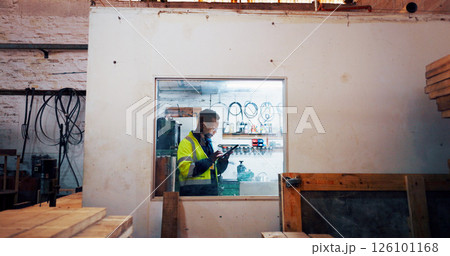 Man, tablet and job at warehouse, industry and scroll with typing report at lumber plant. African person, carpenter and digital touchscreen on application for wood, material or stock order at factory 126101168