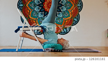 Exercise, upside down or yoga and woman in studio with wall art for fitness or wellness routine. Balance, pilates or profile and senior person in class with mandala symbol for holistic health 126101181