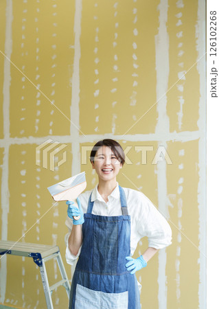 石膏ボードにパテを塗るDIYする女性 126102268