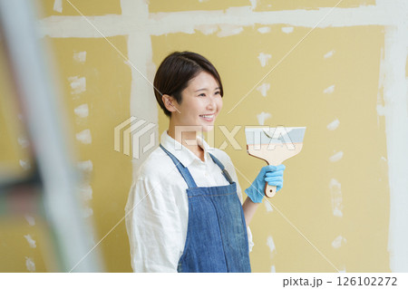 石膏ボードにパテを塗るDIYする女性 石膏ボードにパテを塗るDIYする女性 126102272