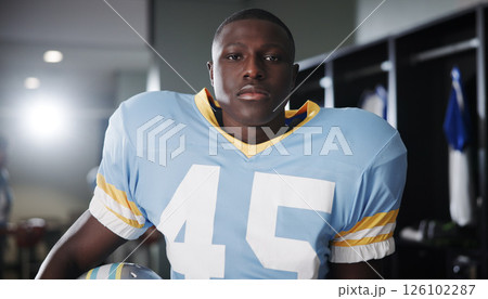Black man, football player or portrait in locker room with confidence, gear or ready for tournament. National sport, fitness or athlete in cloakroom with pride, game preparation or competition in USA 126102287
