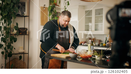 Vegetables, cooking and man with live streaming in kitchen for dinner tutorial, meal prep or cut ingredients in home. Culinary influencer, person or cuisine vlog for content creation and online guide 126102405