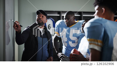 Board, presentation and football with coach and team in locker room for game plan, sports strategy or defense formation. Touchdown tactics, match feedback and discussion with people and advice 126102906